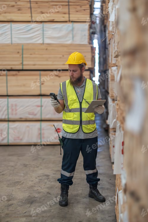 Preview: Warehouse staff verify wooded pallets items using handheld device, ensuring precise shipment.
