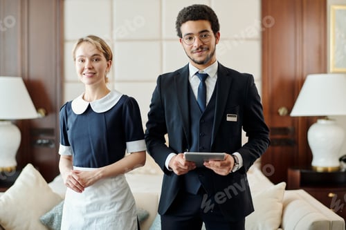 Preview: Young successful staff of luxurious five star hotel standing in room