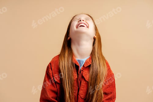 Preview: Cheerful laughing little girl wearing casual jacket standing isolated on beige background