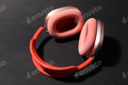 Preview: Pair of stylish pink headphones on black background