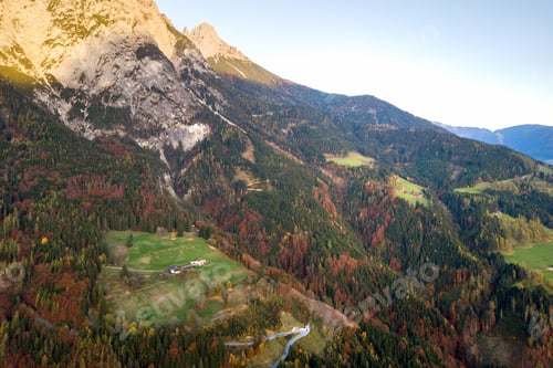 Preview: Aerial view of majestic european Alps mountains covered in evergreen pine forest in autumn.