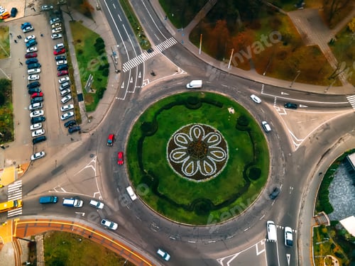 Preview: Aerial view of roundabout road with circular cars in small european city at autumn cloudy day