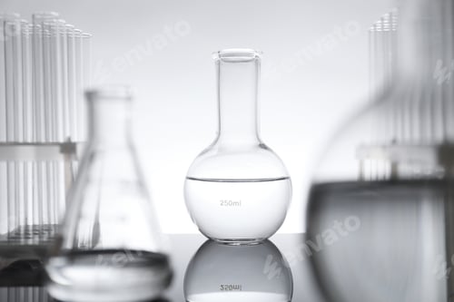 Preview: Laboratory glassware with liquid on mirror surface against light background