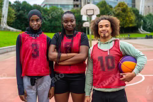 Preview: Diverse basketball team standing on urban court