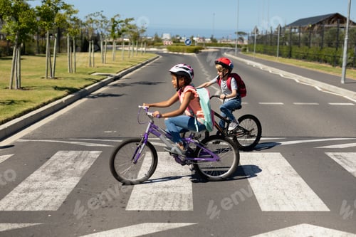 Preview: Schoolgirls crossing the road with bicycles