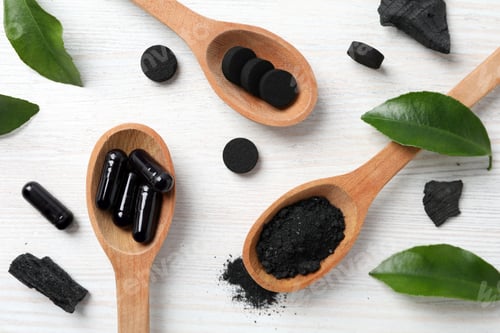 Preview: Activated charcoal tablets in a spoon, top view.