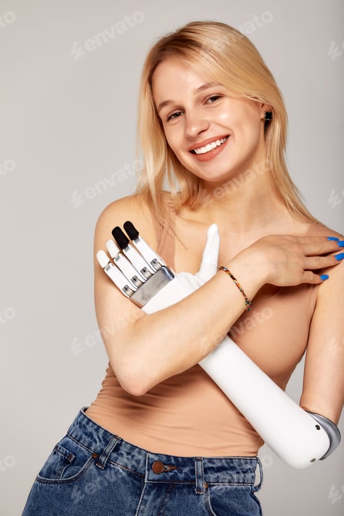 Preview: Studio portrait of beautiful young blonde girl with disability wearing sensory bionic prosthetic arm
