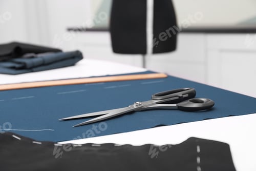 Preview: Fabric and scissors on table in tailor workshop