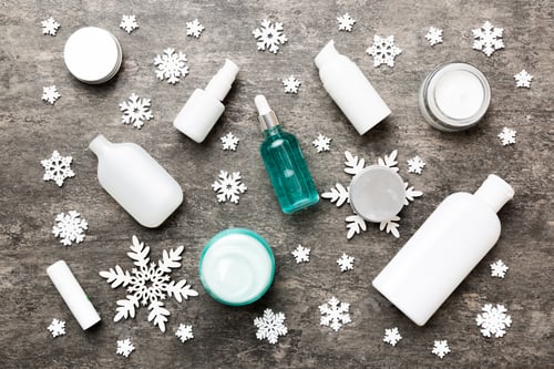 Preview: Makeup products and Christmas decorations on color background. Top view New year Beauty concept