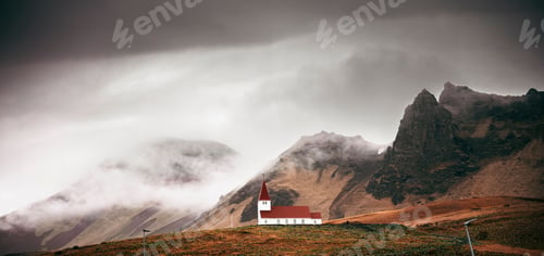 Preview: A scenic view of a church with a red roof amidst misty mountains in Iceland.