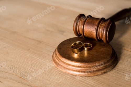 Preview: selective focus of gavel and engagement rings on desk