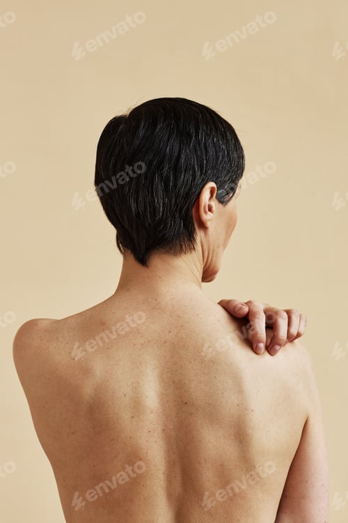 Preview: Adult woman standing with bare back to camera