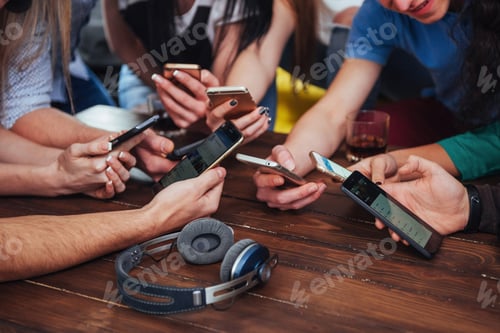 Preview: Top view hands circle using phone in cafe - Multiracial friends mobile addicted interior