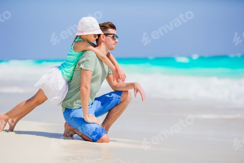Preview: Little girl and happy dad having fun during beach vacation