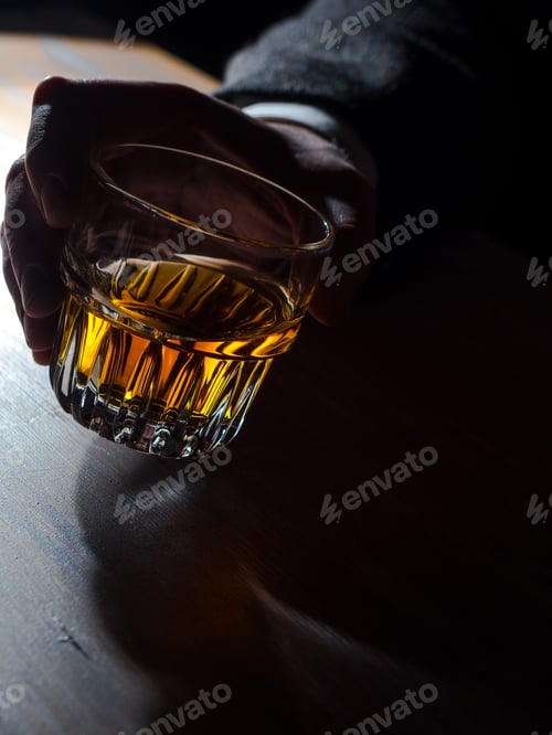 Preview: Man's hand holding a glass of whisky