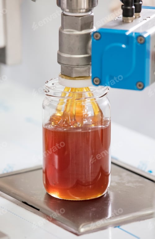 Preview: Filling empty jars with fresh honey in factory.