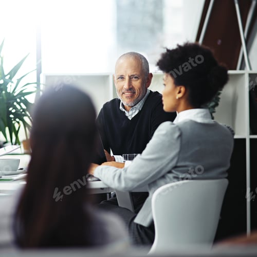 Preview: Portrait of a mature businessman sitting in a meeting with two colleagues