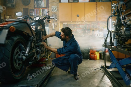 Preview: Young mechanic working on motorcycle in garage repair service