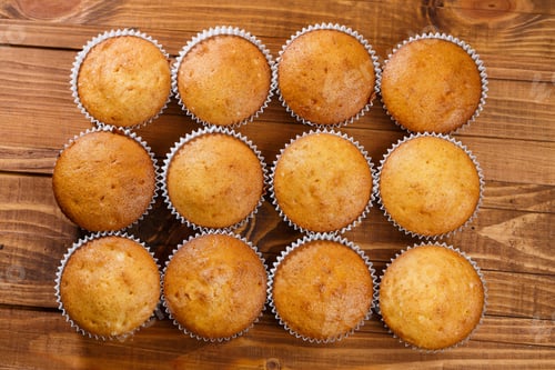 Preview: Homemade muffins in paper wrap on wooden board