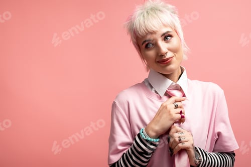 Preview: Charming young woman with a playful demeanor against a soft pink background