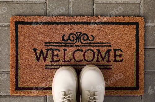 Preview: Door mat with word Welcome and stylish boots on floor, flat lay