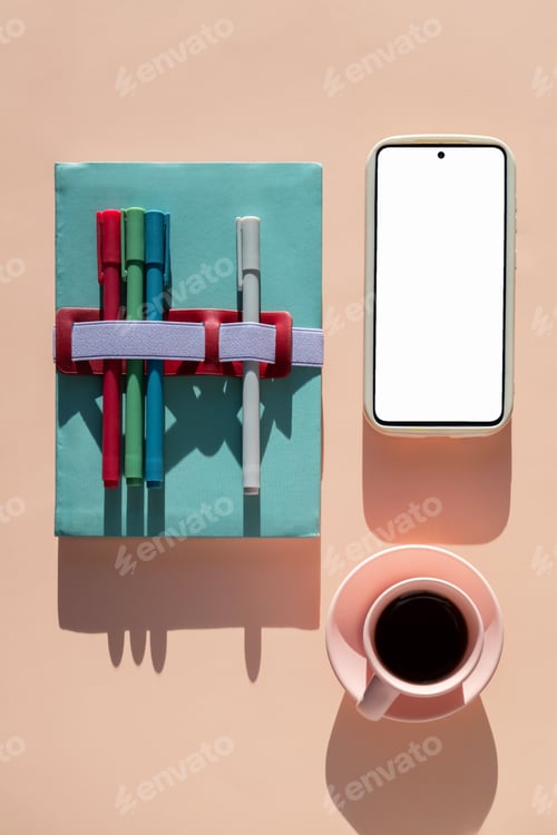 Preview: Notebook with colorful markers, coffee cup and smartphone with blank screen, top view.