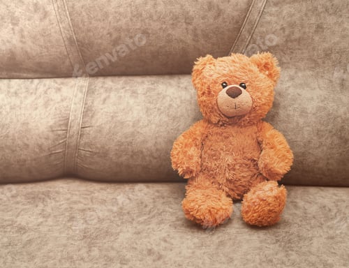 Preview: teddy bear toy sitting on a sofa and looking at a viewer. children safety and loneliness