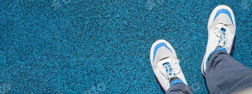 Preview: Man in sports sneakers for running, standing on a rubberized, blue covering outside. Close-up, top