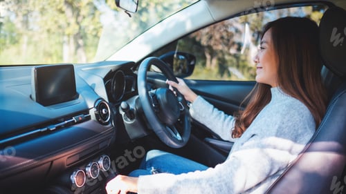 Preview: Closeup image a female driver shifting automatic gear stick while driving car