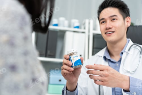 Visualização: Médico especialista asiático do sexo masculino explica o diagnóstico a uma jovem paciente.