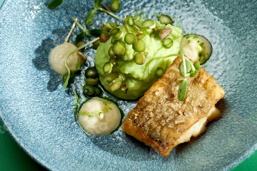 Preview: Fried cod with mashed peas and truffle oil. Bright backgrounds. Hard shadows, selective focus.