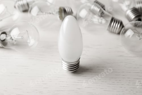 Preview: Frosted and transparent lamp bulbs on white wooden table