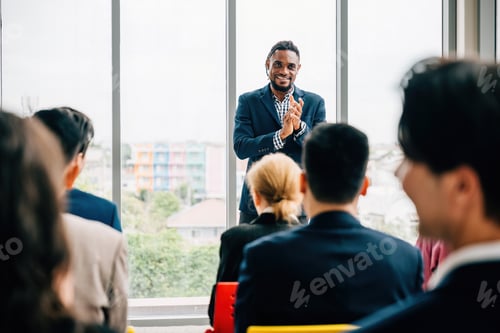 Preview: Business professionals from diverse backgrounds meet in an office, with seated team members