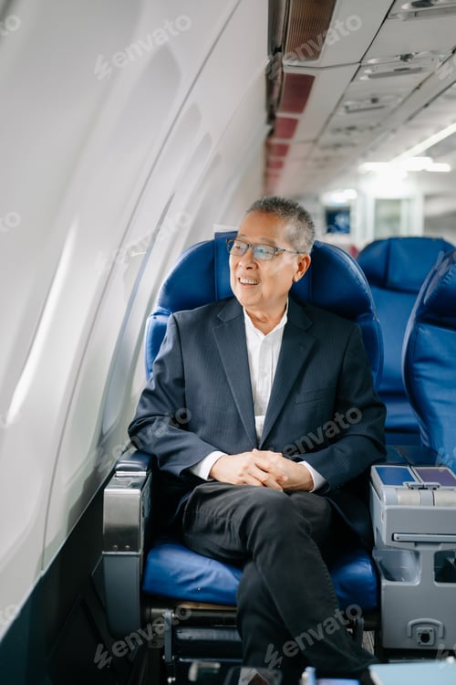 Preview: Asian Mature man sitting in a seat in airplane and looking out the window going on a trip travel