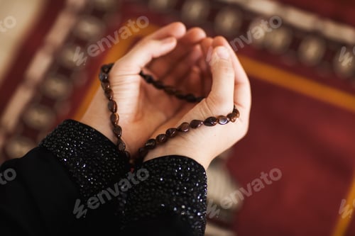 Preview: Prayer hands of a woman holding a rosary