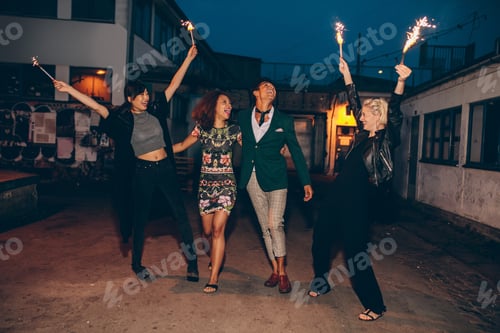 Preview: Group of friends enjoying with sparklers on road