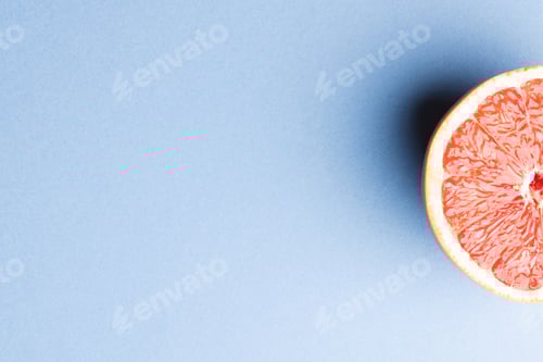 Preview: Close up of half of red grapefruit and copy space on blue background