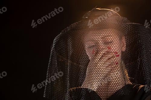 Preview: mourning female dressed in all black for funeral on a black background grim reaper death