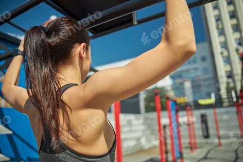 Preview: Serious longhaired brunette looking at sport equipment