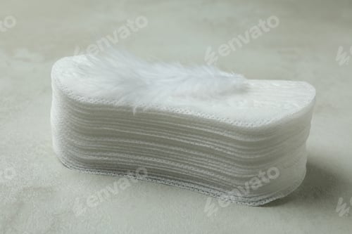 Preview: Stack of sanitary pads on white textured background