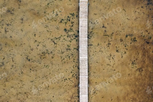 Preview: A wooden dock stretches out across a shallow, brown body of water