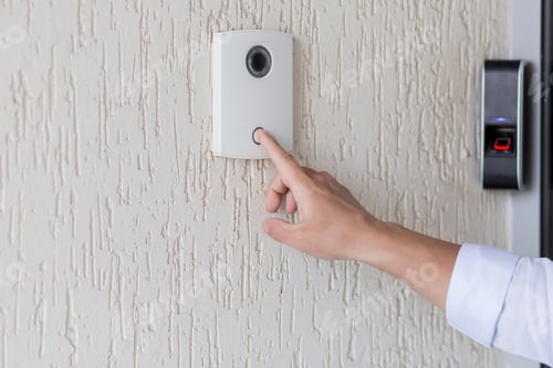 Preview: Hand of a man in a white shirt pressing the button of a door
