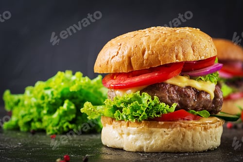 Preview: Hamburger with beef meat burger and fresh vegetables on dark background. Tasty food.