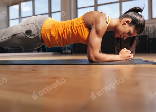 Preview: Muscular female doing core workout in the gym