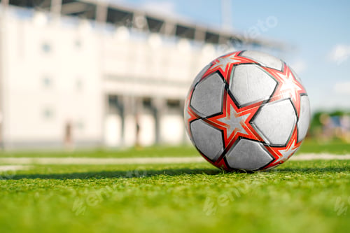 Preview: Soccer ball with stars on green artificial grass of football field