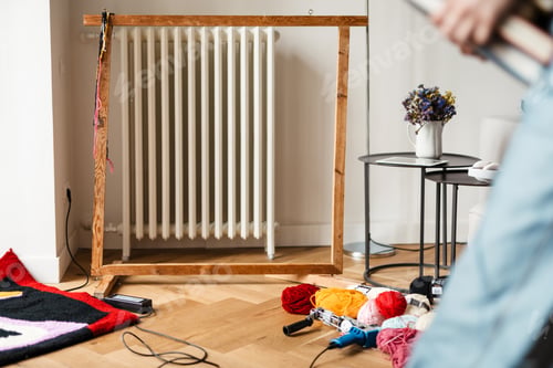 Preview: Photo of workplace rug master with frame and threads at home