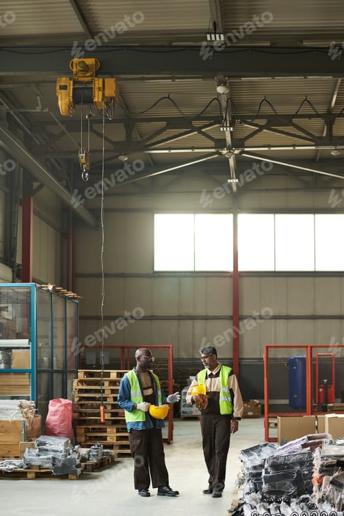 Preview: Industrial Workers Discuss Project Details at Warehouse