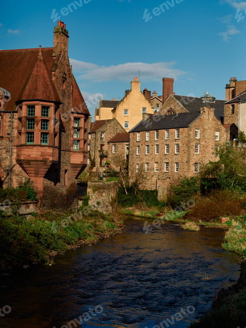 Preview: Historic stone buildings beside a flowing river under a clear blue sky, Edinburgh, Scotland