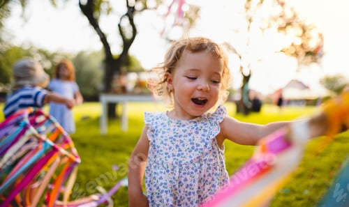 Preview: A front view of small girl on birthday party outdoors in garden in summer.