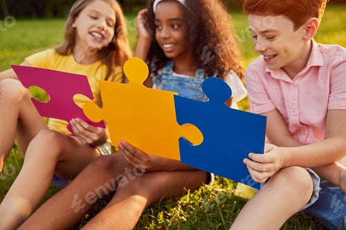 Preview: Company of children playing with puzzles in park